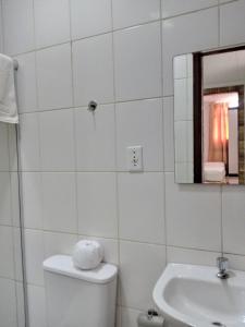 a bathroom with a toilet and a sink and a mirror at Soledade Pousada e Apart Hotel in Morro do Chapéu
