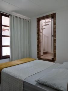 una camera da letto con un letto e uno specchio di Soledade Pousada e Apart Hotel a Morro do Chapéu