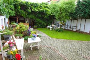 einen Garten mit Tischen, Stühlen und Blumen in der Unterkunft Ferienwohnung Uwe's Sporthütte in Thale