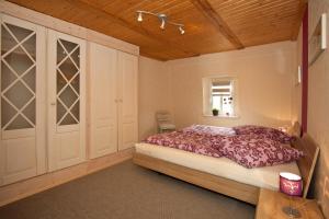 ein Schlafzimmer mit einem großen Bett und einer Holzdecke in der Unterkunft Ferienwohnung Uwe's Sporthütte in Thale