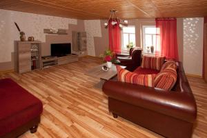ein Wohnzimmer mit einem Sofa und einem TV in der Unterkunft Ferienwohnung Uwe's Sporthütte in Thale