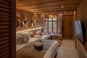 a hotel room with two beds and a flat screen tv at The Spa Resorts - Lamai Beach in Lamai