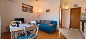 a living room with a table and a blue couch at Apartment Turan in Jelsa