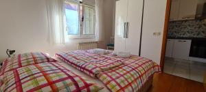 a bedroom with two twin beds and a kitchen at Apartment Turan in Jelsa