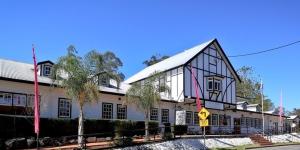 a large white building with a sign in front of it at Canungra Hotel in Canungra