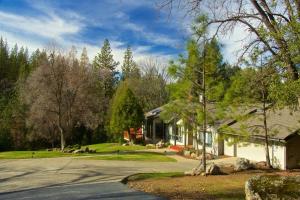 a house with a tree in front of a driveway at Yosemite Nutter Ranch in Mariposa