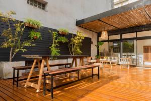 a dining room with benches and plants on the wall at La Casa de Bulnes in Buenos Aires