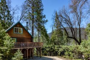 a log cabin in the woods with a deck at Harris Lakeview Cabin in Bass Lake