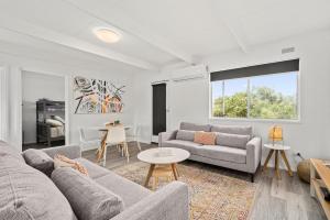 a living room with two couches and a table at The HardyOne - Aldinga Beach - C21 SouthCoast Holidays in Aldinga Beach