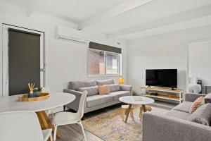 a living room with a couch and a table at The HardyOne - Aldinga Beach - C21 SouthCoast Holidays in Aldinga Beach +25 photos