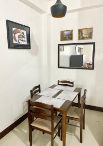 a dining room with a table and chairs and a mirror at Kaitleen Home Stay Door 1 in Tacloban