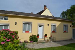 a yellow house with flowers in front of it at L'Araucaria in Pontault-Combault