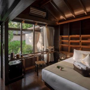 a bedroom with a bed and a desk and a window at The Spa Resorts - Lamai Beach in Lamai +49 photos