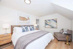 a white bedroom with a bed and a chair at Nantucket Penthouse - walk to restaurants beaches activies & so much more in Half Moon Bay