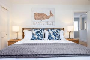 a bedroom with a bed with blue and white pillows at Nantucket Penthouse - walk to restaurants beaches activies & so much more in Half Moon Bay