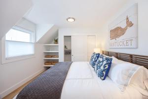 a bedroom with a large bed with blue and white pillows at Nantucket Penthouse - walk to restaurants beaches activies & so much more in Half Moon Bay