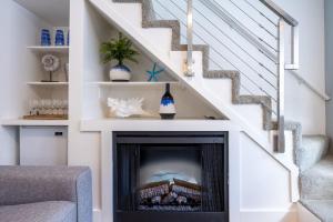 a fireplace in a living room with a staircase at Nantucket Penthouse - walk to restaurants beaches activies & so much more in Half Moon Bay
