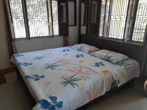 a bedroom with a bed with a floral bedspread at Jungle View Home Stay in Dogadda