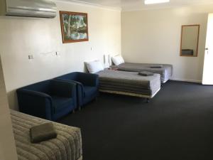 a hotel room with two beds and a couch at Charleville Waltzing Matilda Motor Inn in Charleville +14 photos