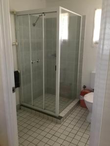 a shower stall in a bathroom with a toilet at Charleville Waltzing Matilda Motor Inn in Charleville