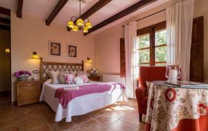Un dormitorio con una cama y una mesa en una habitación. en Hotel de Montaña Cueva Ahumada, en Villaverde de Guadalimar 37 fotos más