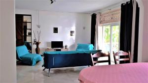 a living room with a blue couch and a desk and chairs at Apt in La Gaulette in La Gaulette