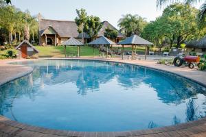 ein großer Pool vor einem Haus in der Unterkunft Aan De Vliet Holiday Resort in Hazyview