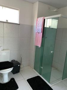 y baño con ducha de cristal y aseo. en Apartamento Mobiliado para seu conforto en Caruaru