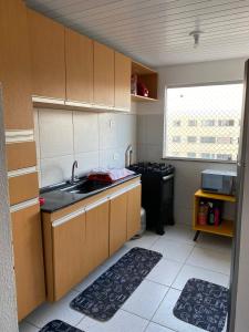 eine kleine Küche mit einer Spüle und einem Herd in der Unterkunft Apartamento Mobiliado para seu conforto in Caruaru
