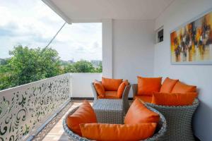 balcón con sillas acolchadas de color naranja en RedDoorz Plus near Patung Kuda Undip, en Jatingaleh