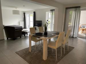 einen Esstisch und Stühle im Wohnzimmer in der Unterkunft Modernes Appartement in Gladbeck