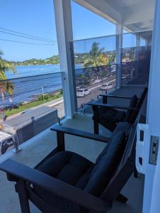 - une rangée de tables sur un balcon avec vue sur la plage dans l'établissement Inn The Town, à Port Antonio