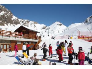 a group of people standing in the snow at a ski lodge at Rifugio 2000 in Alpe Ciamporino +20 photos