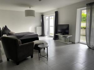 ein Wohnzimmer mit einem Sessel und einem TV in der Unterkunft Modernes Appartement in Gladbeck