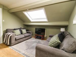 a living room with two couches and a skylight at West Cottage in Malton