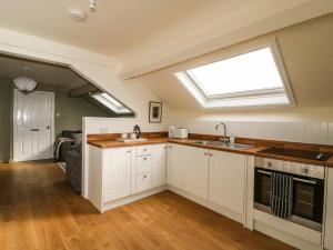 a kitchen with a sink and a skylight at West Cottage in Malton