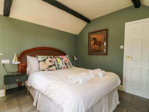 ein Schlafzimmer mit einem Bett mit Handtüchern darauf in der Unterkunft Cowshed Cottage in Malton