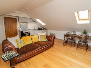 a living room with a brown couch and a table at The Hideaway in St Ives +6 photos