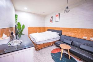 Ch'ang-p'ing的住宿－漚汪水岸，一间卧室配有一张床和一张皮沙发