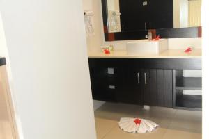 y baño con lavabo, espejo y encimera. en Lander's Bay Resort, en Lautoka