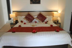 a bedroom with a large bed with red flowers on it at Lander's Bay Resort in Lautoka