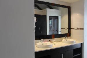 un bagno con due lavandini e un grande specchio di Lander's Bay Resort a Lautoka