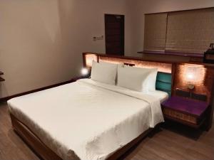 a bedroom with a large bed with white sheets at Great Trails Wayanad by GRT Hotels in Wayanad