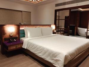 a bedroom with a large bed and a bathroom at Great Trails Wayanad by GRT Hotels in Wayanad