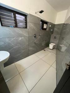 a bathroom with a shower and a toilet and a sink at PMR GRANDAYS in Malappuram