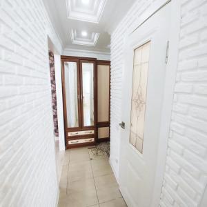 a hallway with a door and a tile floor at Красивый однокомнатный люкс в районе вокзала in Karagandy