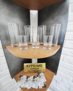 un groupe de verres assis sur une étagère dans l'établissement Красивый однокомнатный люкс в районе вокзала, à Karaganda