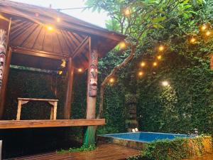 a pavilion with a swimming pool in a garden at Kenting Afei Surf Hostel Nanwan in Nanwan