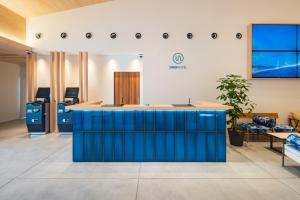 un hall de bureau avec une île bleue au milieu dans l'établissement UNO HOTEL, à Tamano
