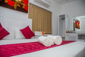a bedroom with a bed with towels on it at Niwahana Transit City Hotel in Katunayake